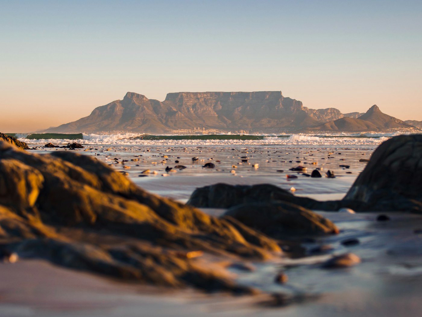 Table Mountain at golden hour, seen across the surf from Bloubergstrand.